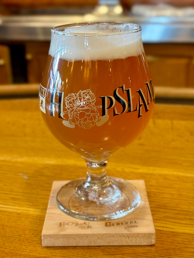 Clear snifter glass with Hopslam logo in green and black and Hopslam person printed around the middle