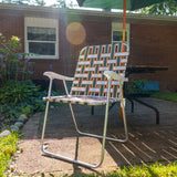 Classic folding lawn chair with aluminum frame with webbing in Two Hearted colors, olive green, orange and white, with white plastic armrests. Featuring Two Hearted Logo in orange font with green outline on back middle right side of chair.