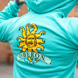Teal hoodie, large yellow and orange Oberon sun logo on the back.
