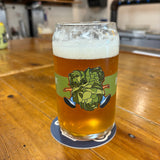 Clear can-shaped glass with Hopslam person logo, filled with Hopslam,