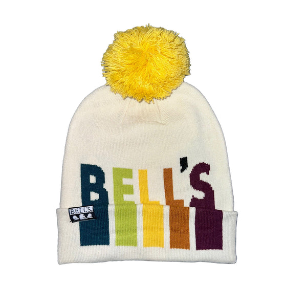 Cream knit winter hat with Bell's featured in shades of navy, lime green, yellow, burnt orange, and maroon. Features a yellow pom on top. Bell's tag sewn into the brim.