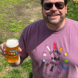 Purple short sleeve tee shirt with multi colored glassware arranged in a circle around Celebrate Diversty in black at the center. Black Bell's logo in the center between Celebrate and Diversity.