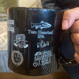 Black coffee mug with multiple Bell’s Beer logos.