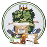 Round tin sign featuring Hopslam logo. Kit ingredients in front, including malt, hops, priming sugar, and honey