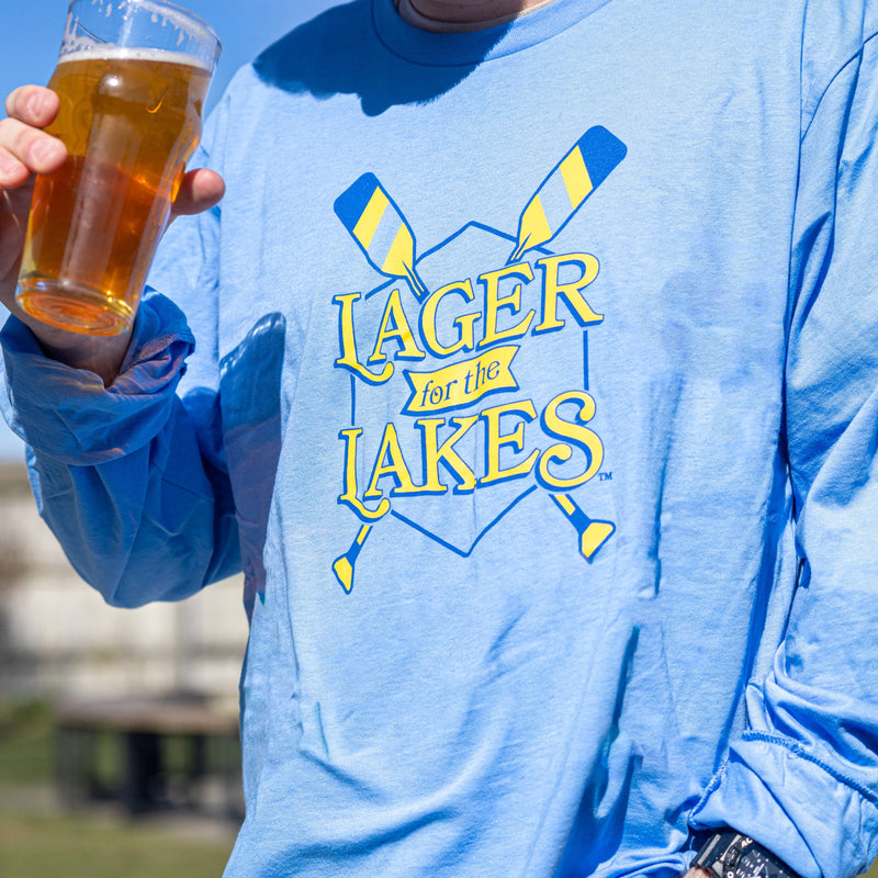 Lightweight light blue long sleeve t-shirt with Lager for the Lakes logo and two oars in royal blue and lemon yellow screen printed across the chest.
