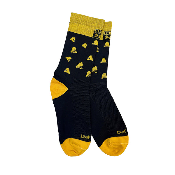 A pair of socks on a white background.  The socks have a yellow toe and heel, a pattern of bells on the ankle, and the Bell's logo on a yellow background at the top.