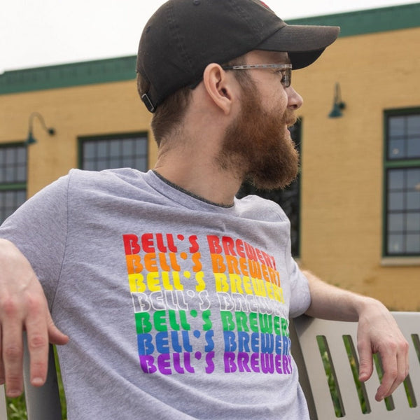 Light heathered grey short sleeved tee shirt with Bell's Brewery screen printed multiple times down the front in various colors, red, orange, yellow, white outline, green, blue, and purple. 