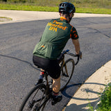 Olive green bike jersey with orange and green camo on the sleeves, with orange collar. The back has large Two Hearted IPA logo on the back, and an orange Bell's logo above it. The back also features Borah logo in orange over middle pocket.