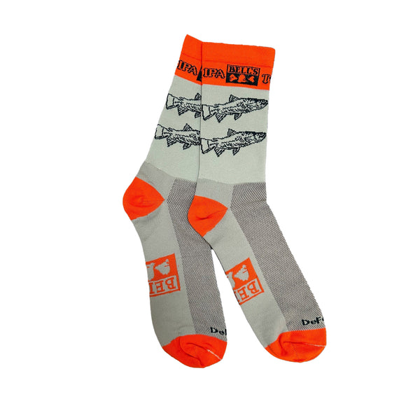 Light green crew socks with orange accents at the heel, toe, and calf. Orange Bell's logo on the sole of the foot. Two green fish on the ankle of each sock. Two Hearted IPA logo in green on the orange calf accent.
