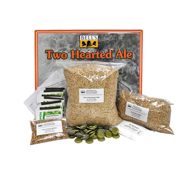 Kit featuring bags of Briess malt, a bag of priming sugar, bottle caps, packets of centennial hops and a rectangle Two Hearted Ale tin sign.