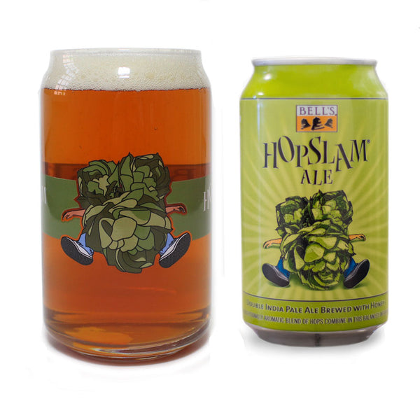 Clear can-shaped glass with Hopslam person logo, filled with Hopslam, sitting next to a can of Hopslam Ale.