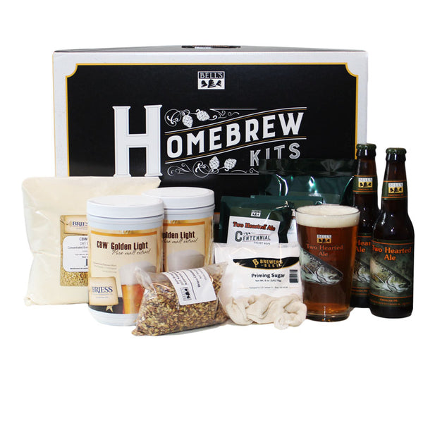 Homebrew kit box in the background with ingredients in the front, including malt extract, malt, priming sugar, centennial hops. Also includes two bottles of Two Hearted and a pint glass with the beer liquid.