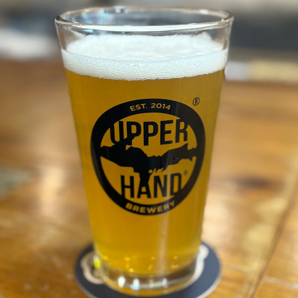 Clear pint glass with black 'drink u.p.' and 'Upper Hand' logos