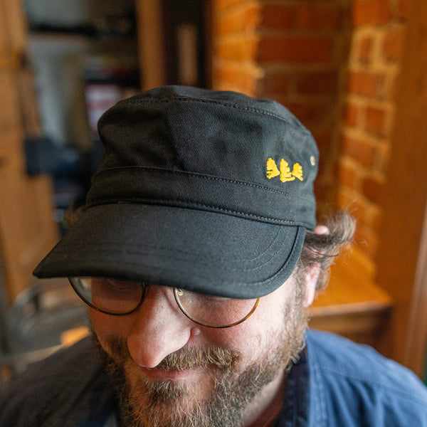 black "cadet" or military cut hat with yellow Bell's logo on left front.  full logo pinch tag on the back with adjustable starp