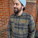 Green with black and orange button up flannel, with two pockets and the "Two Hearted IPA" in orange letters embroidered over the left pocket