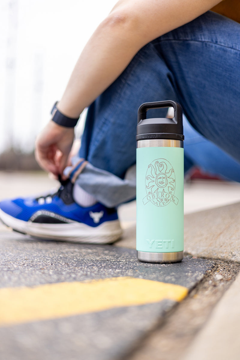 Seafoam blue Yeti 18oz water bottle with silver metallic Oberon logo embossed in the center and a black lid.