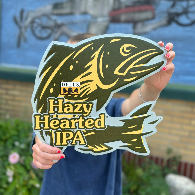 Hazy Hearted fish shaped tin sign with Bell's Hazy Hearted IPA logo, features colors of yellow and olive green.