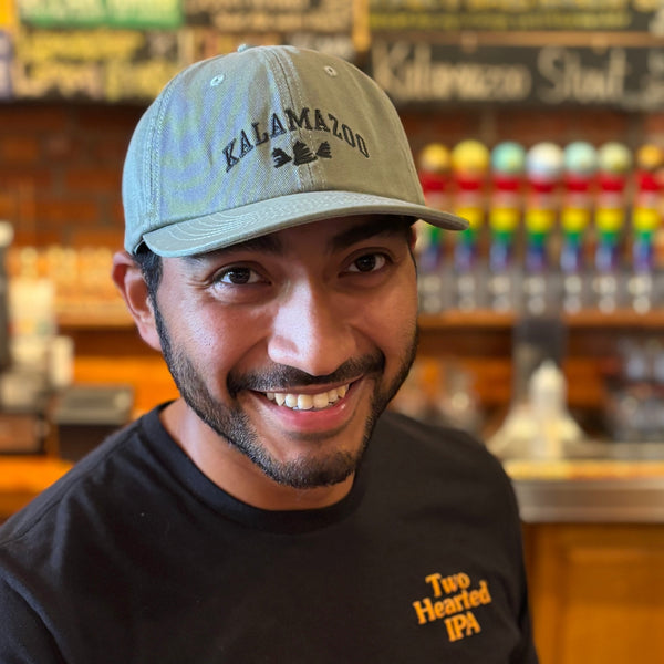 olive green dad hat with Kalamazoo "college" style logo with Bell's bells beneath text