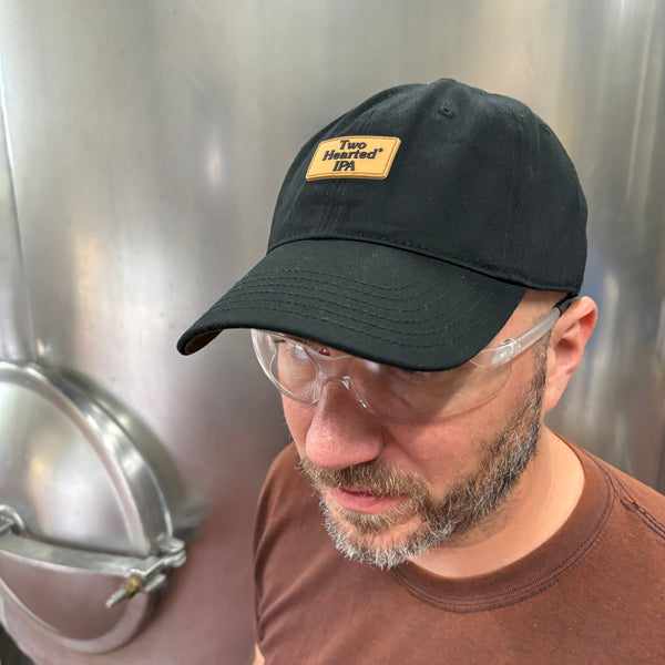 black dad hat with light brown silicone rectangular silicone patch  with "Two Hearted IPA" in black