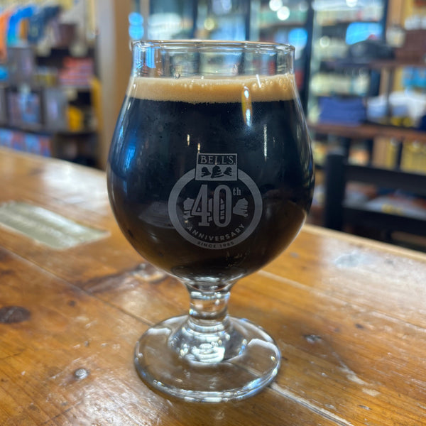 Dark beer in a 16oz snifter glass showing off the 40th anniversary engraved logo.
