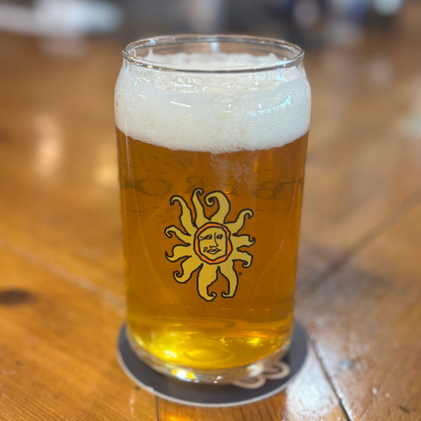 16 ounce can shaped drinking glass with full color Oberon sun on the front, and Oberon printed on the back with sunburst lines surrounding text