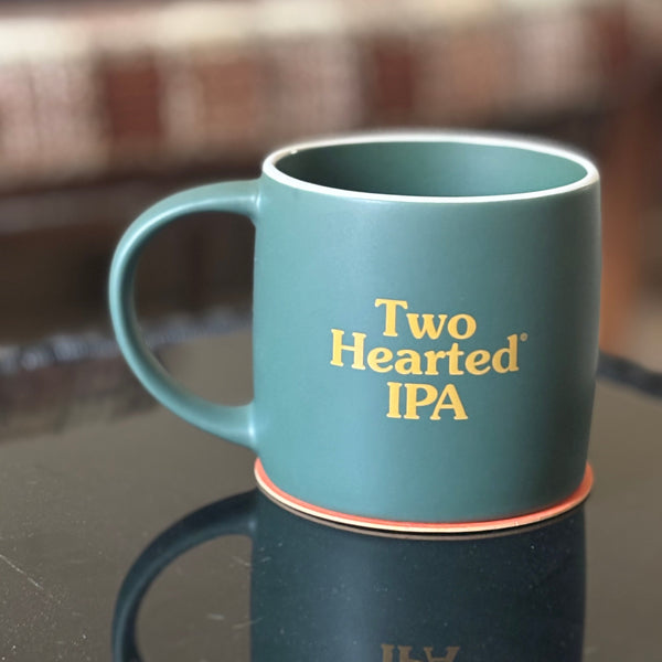 dark green matte finish 17oz mug with white upper rim.  Two Hearted IPA printed in orange text on both sides.