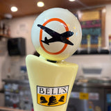 off white tap globe with dark blue plane in front of orange oval