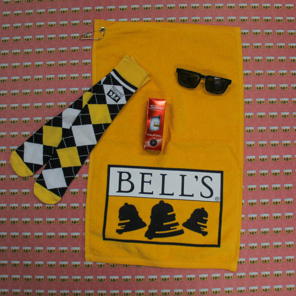 Yellow golf towel, bell's black white and yellow argyle socks, black and yellow bell's sunglasses and bell's logo titleist 3 back of golf balls