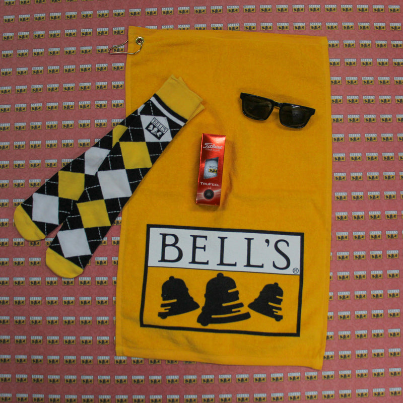 Yellow golf towel, bell's black white and yellow argyle socks, black and yellow bell's sunglasses and bell's logo titleist 3 back of golf balls