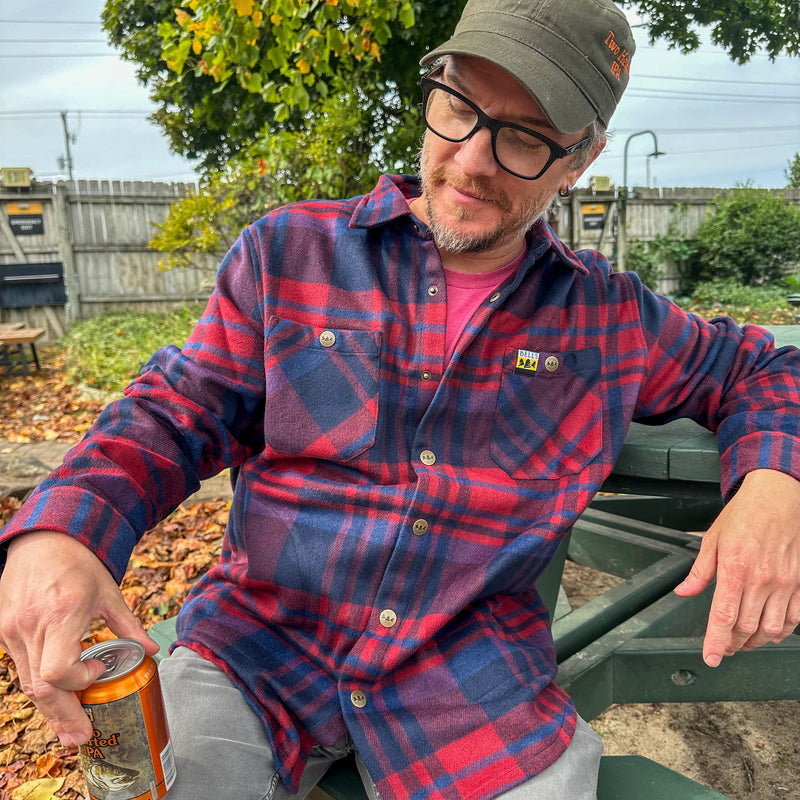 Plum, blue and red plaid shacket, with Bell's logo bronze color metal snaps with Bell's logo, also featuring full color logo on left pocket