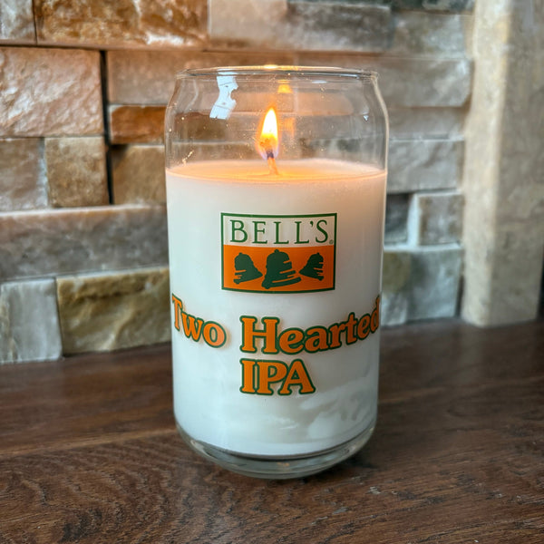 can glass white candle with Two Hearted IPA spelled out in orange with green border.  also featuring Bells logo in green and orange