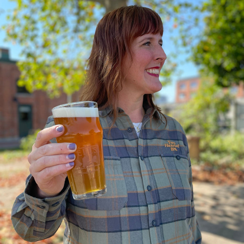 Green with black and orange button up flannel, with two pockets and the "Two Hearted IPA" in orange letters embroidered over the left pocket