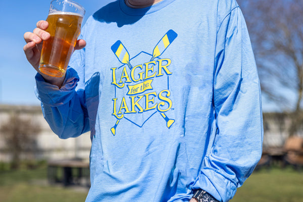 Lightweight light blue long sleeve t-shirt with Lager for the Lakes logo and two oars in royal blue and lemon yellow screen printed across the chest.