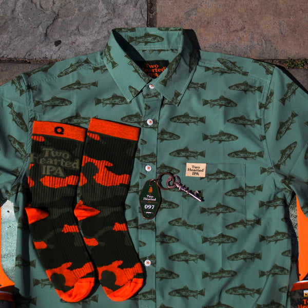 Green Two Hearted IPA shirt with darker green trout printed all over and beige pinch tag on pocket with green logo on.  Also, orange and green camo socks with green Two Hearted Logo printed on. Finally, a copper colored keychain with "hotel style" green style and copper trout shaped bottle opener.