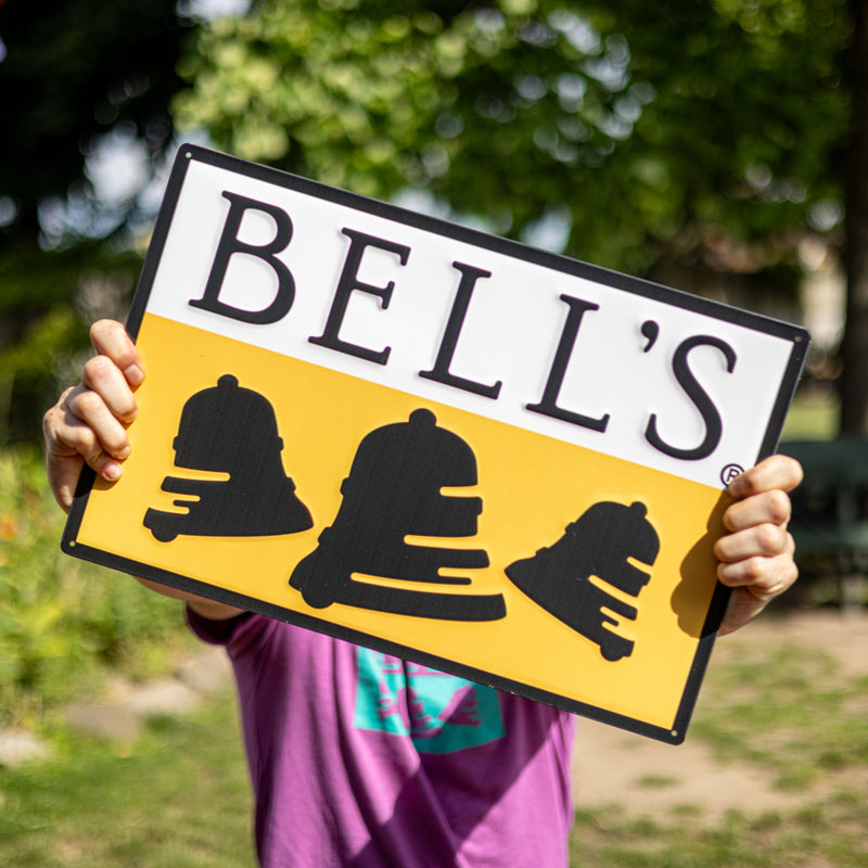 Horizontal tin sign of the black, white, and yellow Bell's logo