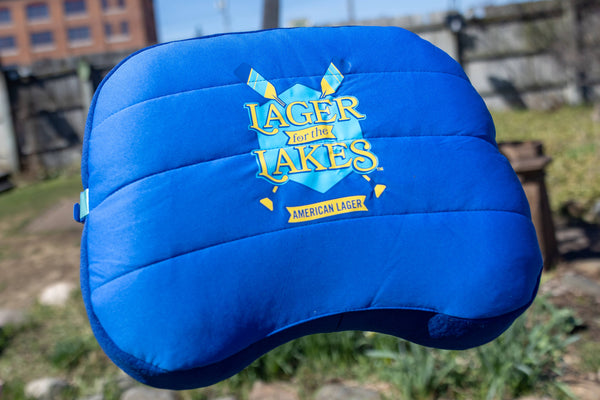 Blue inflatable pillow with blue nylon bag attached.  Lager for the Lakes logo on the center.
