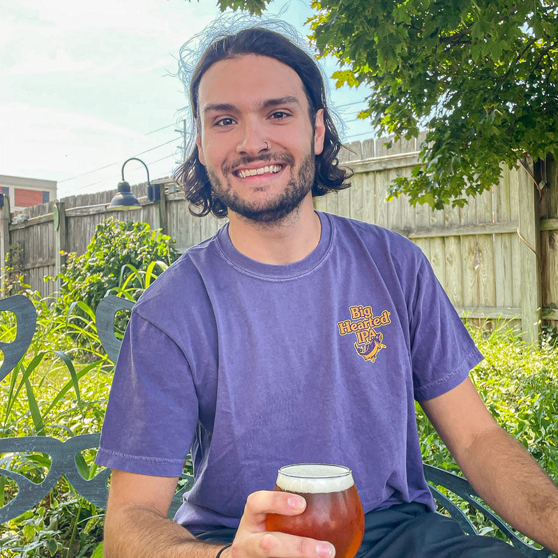 Purple short sleeve tee shirt with small Big Hearted logo on left pocket of front.  Logo is Big Hearted IPA in Orange with gold outline, with green and orange trout
