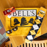 Yellow golf towel, bell's black white and yellow argyle socks, black and yellow bell's sunglasses and bell's logo titleist 3 back of golf balls