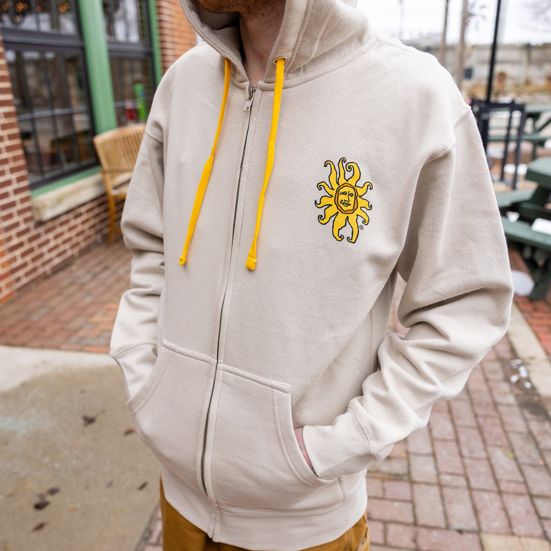 bone white zip up hoodie with color Oberon Sun on pocket area.  Also features yellow drawstring for hood