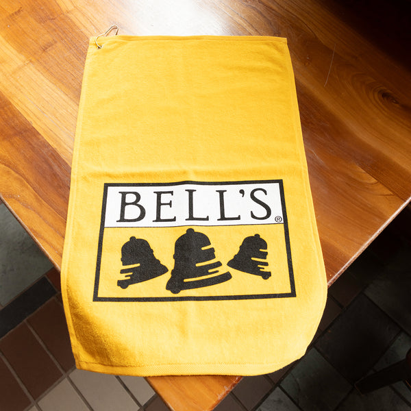 Golden yellow golf towel with Bell's Logo and Inspired Brewing printed on it.
