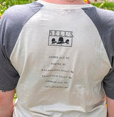raglan-style t-shirt with a cream-colored body and dark gray sleeves. The back of the shirt features a black graphic print for 'BELL'S' with beer names listed underneath.
