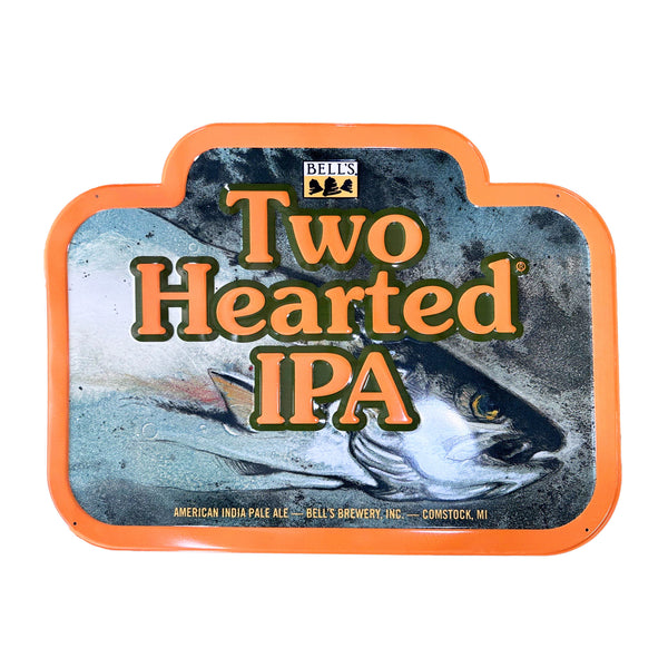 Rectangular-like Two Hearted IPA tin sign featuring the Two Hearted fish artwork and Two Hearted IPA text. Yellow, black and white Bell's logo top center. Bottom text in pale yellow: American India Pale Ale - Bell's Brewery, Inc. - Comstock, MI. Has an orange border around sign.