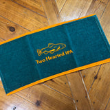 Deep green towel with orange borders, orange “Two Hearted IPA” text and orange fish logo above it