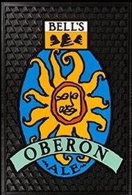 Black bar serve mat with bell texture. Features the Oberon Ale logo in various blues, yellow, and orange. Bell's logo in yellow, black and white centered at the top.