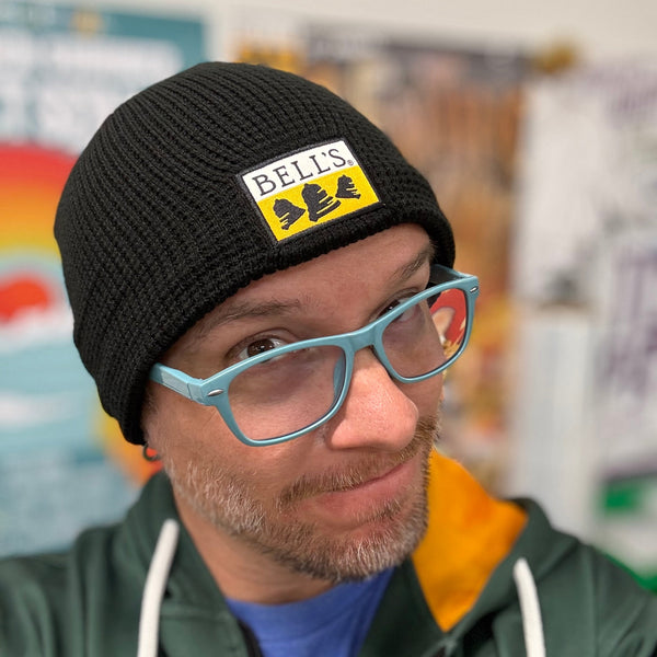 Person wearing a black beanie with patch 'Bells' logo in front center