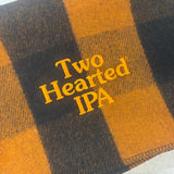 orange buffalo check wool blanket with brighter orange embroidered "Two Hearted IPA" on bottom right corner