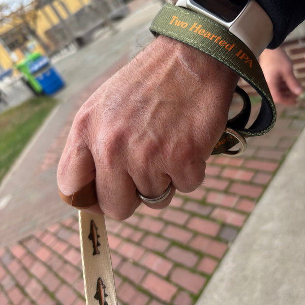 off white dog leash with full color Two Hearted brand fish pattern.  handle is dark green with orange Two hearted IPA text logo repeated