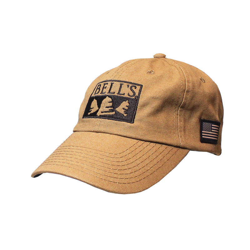 Tan twill baseball cap with black embroidered Bell's logo on the front and an American flag embroidered on the side.